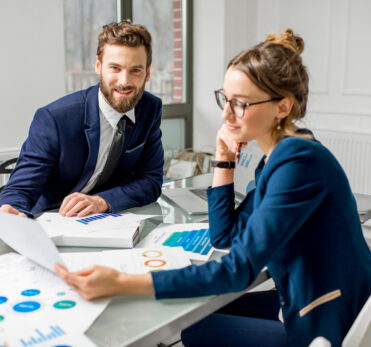 marketing-oder-analysemanager-team-in-anzuegen-die-mit-papierkarten-und-laptops-im-weissen-bueroinnenraum-arbeiten